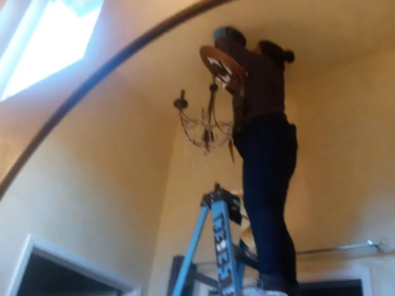 Electrician installing a chandelier in a Stonecrest residence